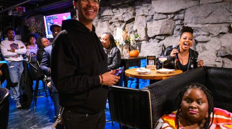 Armenta Pierre (right, holding microphone) explained her vote on a ballot question at an election night watch party at Estella in Downtown Boston Nov. 5, hosted by Boston While Black. James “Jimmy” Hills, host of talk show "Java with Jimmy," stands at left.